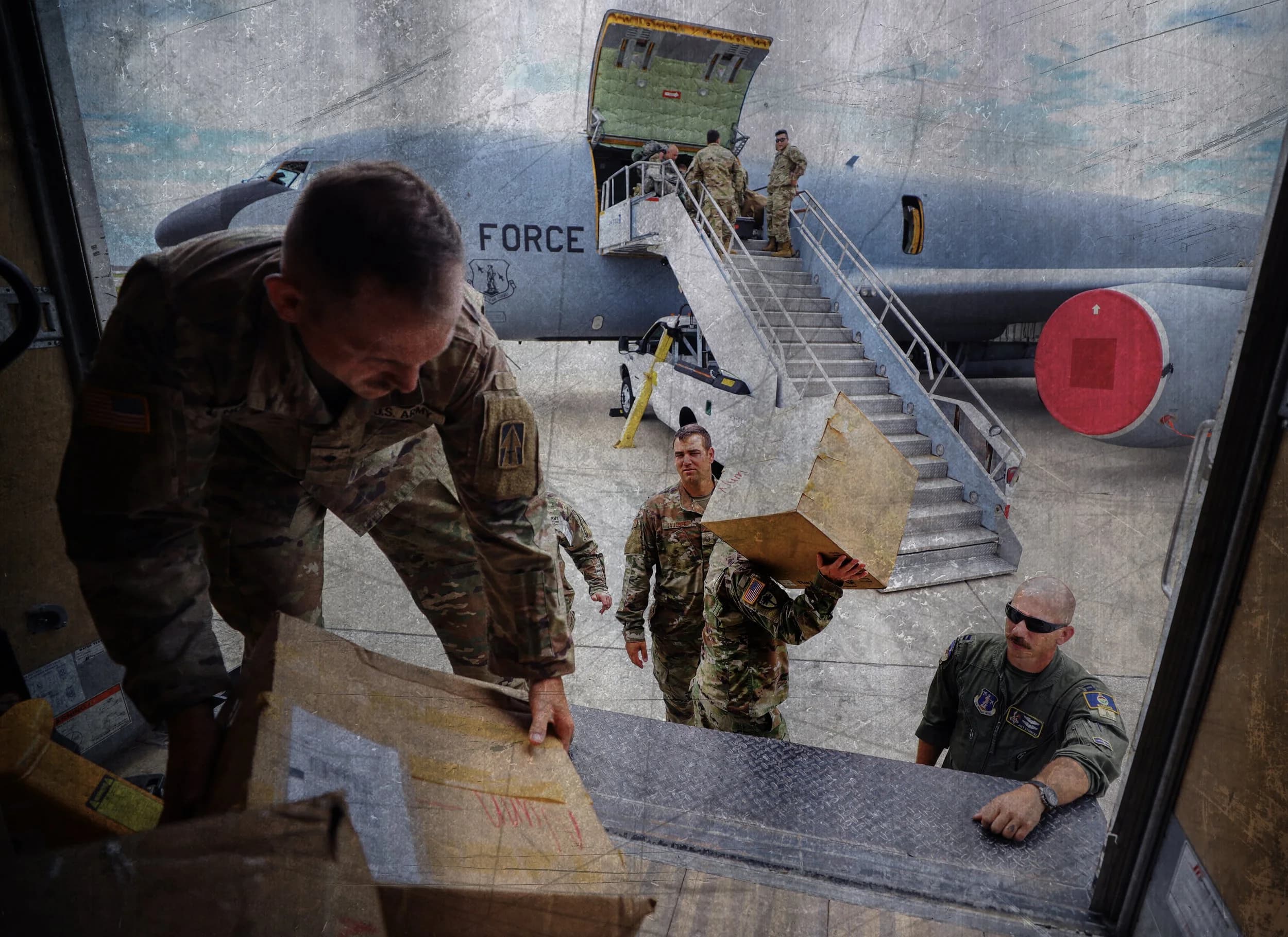Service members working on equipment in a hangar