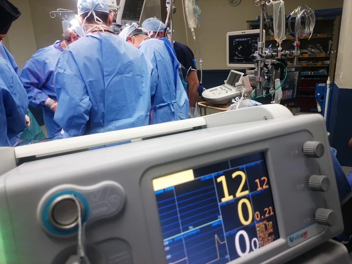 Surgical team working around monitoring equipment in an operating room