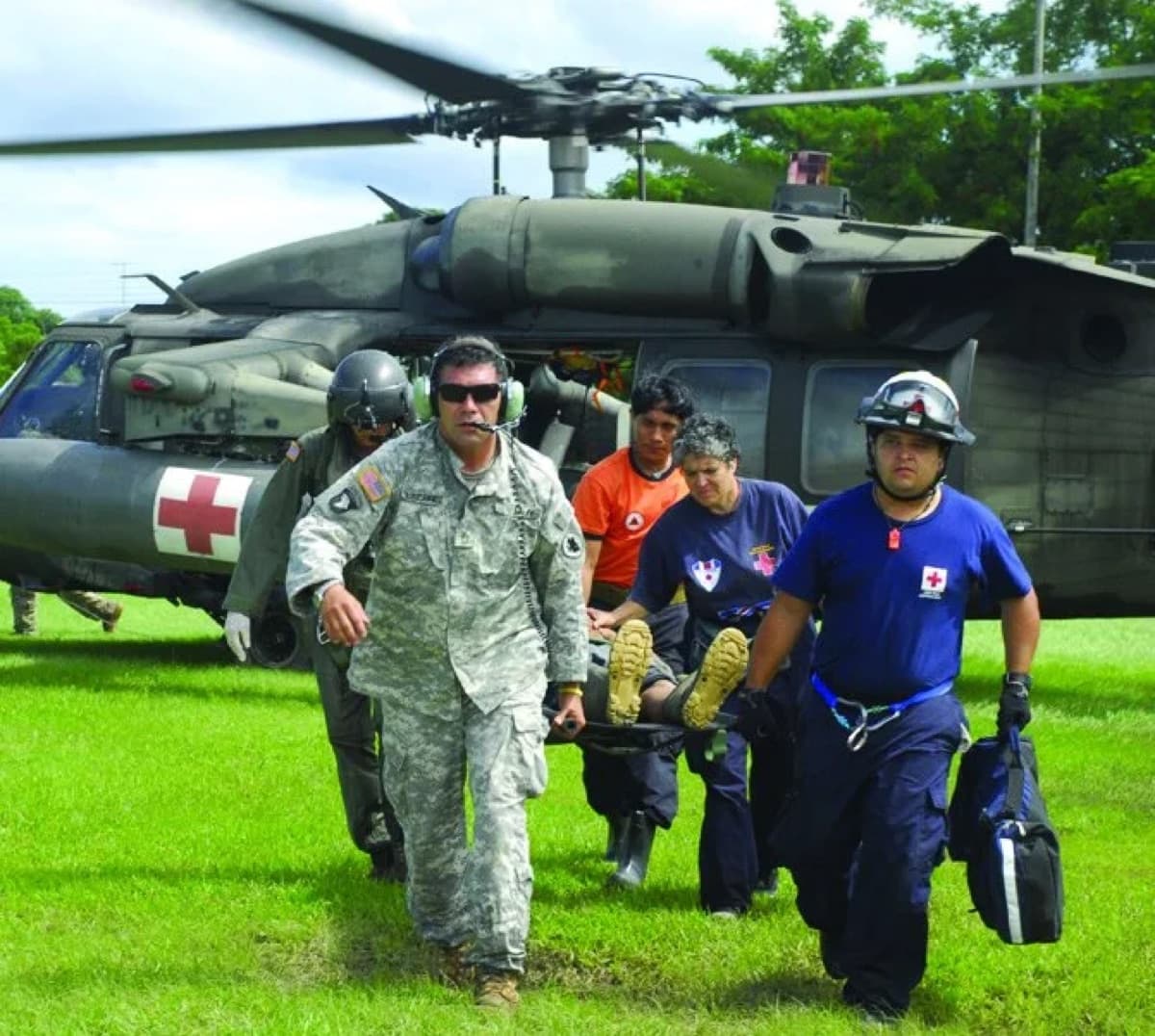 Medical team carrying a patient on a stretcher from a helicopter